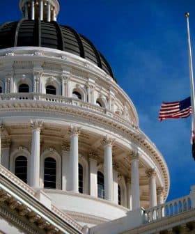 Close-up view of the California State Capitol building with a flag at half-mast. - Olive Oil Times