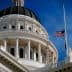 Close-up view of the California State Capitol building with a flag at half-mast. - Olive Oil Times