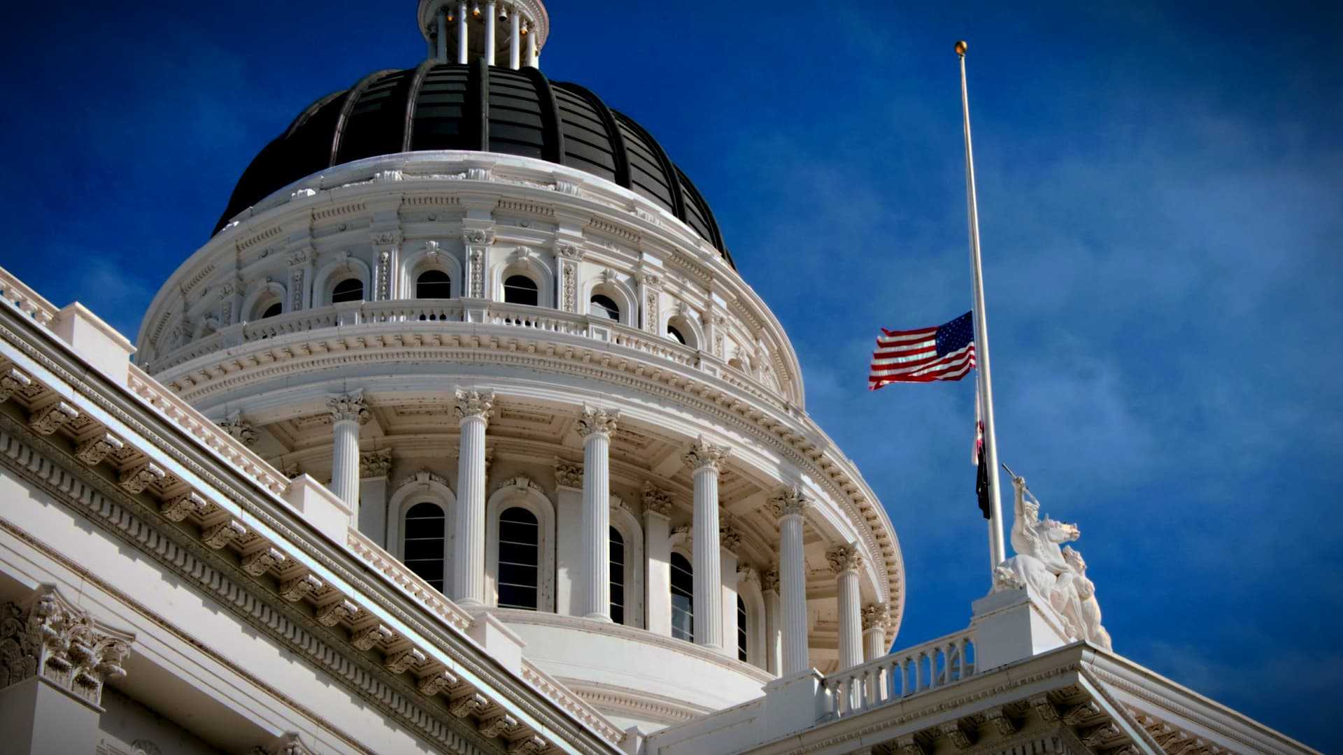 Close-up view of the California State Capitol building with a flag at half-mast. - Olive Oil Times