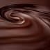 Smooth, swirling texture of dark chocolate with a glossy finish. - Olive Oil Times