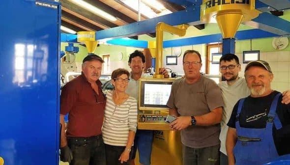 Six individuals standing in an olive oil production facility near machinery and equipment. - Olive Oil Times