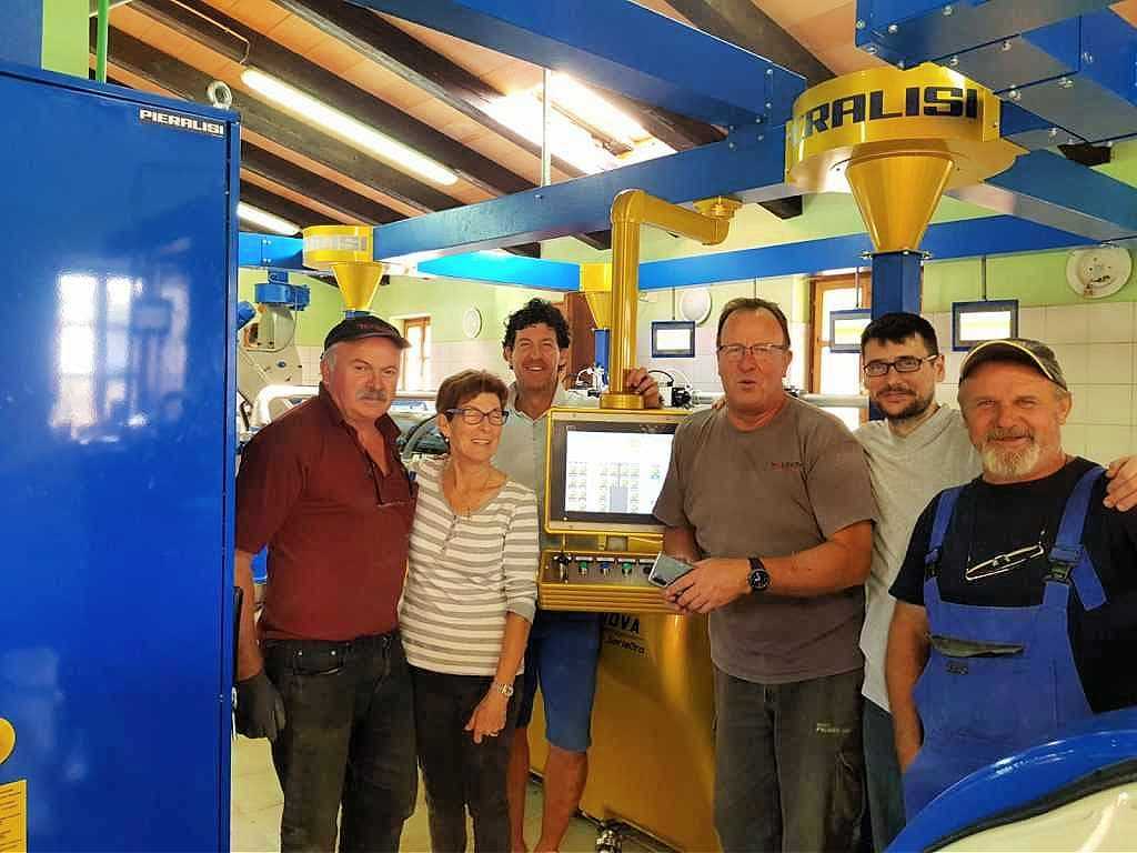 Six individuals standing in an olive oil production facility near machinery and equipment. - Olive Oil Times