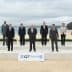 Group photo of G7 leaders standing on a stage at a beach in Cornwall. - Olive Oil Times