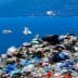 A large pile of mixed waste with seagulls flying above it against a blue ocean background. - Olive Oil Times