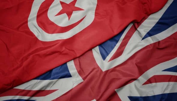 Close-up of the flags of Tunisia and the United Kingdom laid out together. - Olive Oil Times
