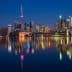 Toronto city skyline featuring the CN Tower and illuminated buildings reflected in water at night. - Olive Oil Times