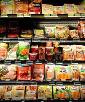 Various packaged food items displayed on a grocery store shelf, including meats and snacks. - Olive Oil Times
