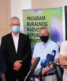 A group of four individuals standing together at a press conference, wearing masks and formal attire. - Olive Oil Times