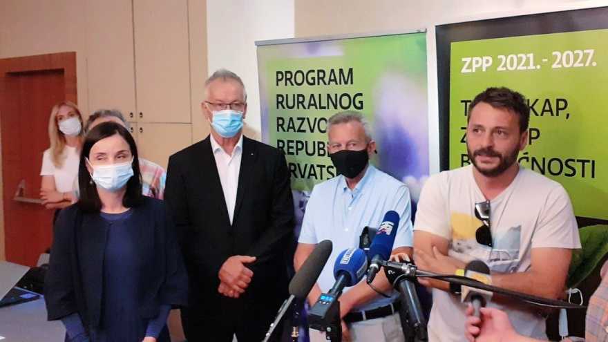 A group of four individuals standing together at a press conference, wearing masks and formal attire. - Olive Oil Times