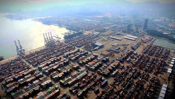 Aerial view of a busy container port with numerous shipping containers stacked. - Olive Oil Times