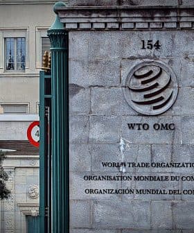 Sign of the World Trade Organization located at its headquarters with multiple languages displayed. - Olive Oil Times