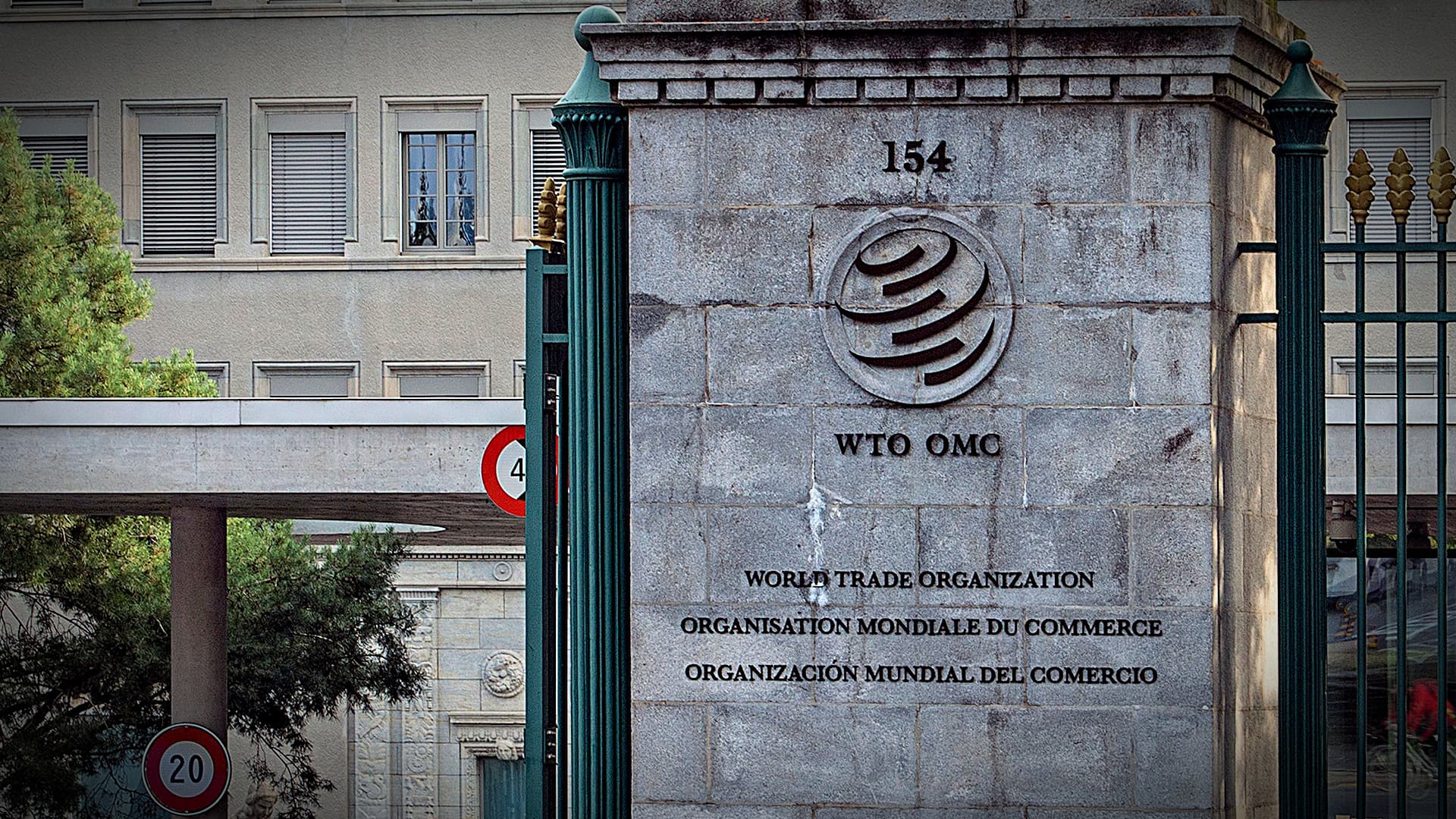Sign of the World Trade Organization located at its headquarters with multiple languages displayed. - Olive Oil Times