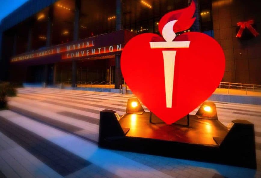 Large red heart symbol with a torch in front of a convention center entrance. - Olive Oil Times