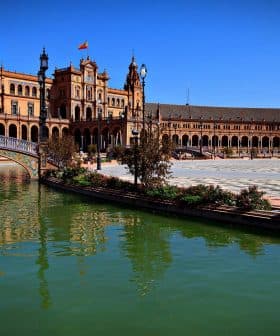 Plaza de España in Seville with a water canal and architectural structures in the background. - Olive Oil Times