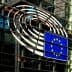 European Union flag displayed on the glass exterior of a building with circular design elements. - Olive Oil Times