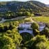 Aerial view of Chateau d'Estoublon surrounded by vineyards and trees. - Olive Oil Times