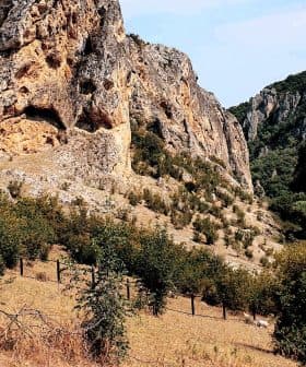 Rocky terrain featuring steep cliffs and scattered trees in a natural setting. - Olive Oil Times