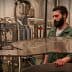 A man with a beard overseeing machinery in an oil production facility. - Olive Oil Times