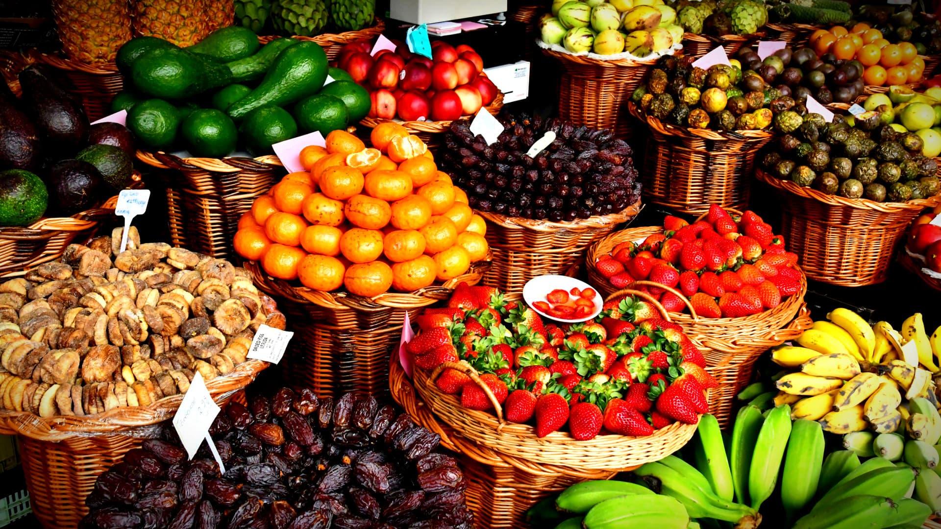 Baskets filled with various fresh fruits including oranges, strawberries, and bananas. - Olive Oil Times
