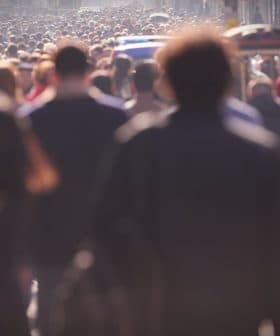 A large crowd of people walking on a busy city street during daylight hours. - Olive Oil Times