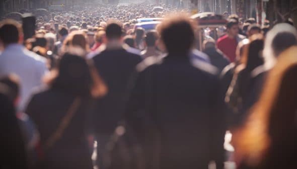 A large crowd of people walking on a busy city street during daylight hours. - Olive Oil Times