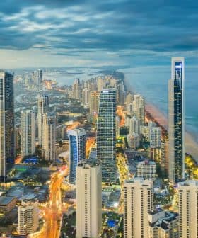 Aerial view of Gold Coast city skyline with high-rise buildings and coastline at dusk. - Olive Oil Times