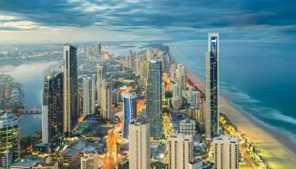 Aerial view of Gold Coast city skyline with high-rise buildings and coastline at dusk. - Olive Oil Times