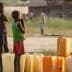 Two children standing beside yellow water containers in an outdoor setting during daylight. - Olive Oil Times