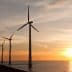 Row of wind turbines along the coastline during sunset with a colorful sky. - Olive Oil Times