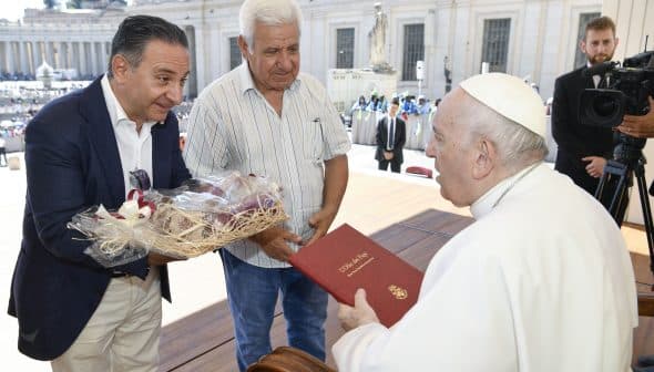 Two men presenting gifts to Pope Francis during a meeting at the Vatican. - Olive Oil Times
