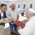 Two men presenting gifts to Pope Francis during a meeting at the Vatican. - Olive Oil Times