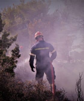 Firefighter wearing protective gear working in a smoky environment during a fire response operation. - Olive Oil Times