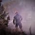 Firefighter wearing protective gear working in a smoky environment during a fire response operation. - Olive Oil Times
