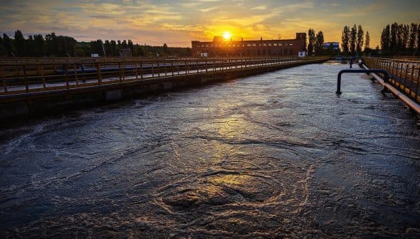 Water treatment facility with a view of the sunset reflecting on the water surface. - Olive Oil Times