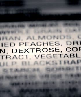 Close-up of an ingredient list on food packaging showing various components including dried fruits and glycerin. - Olive Oil Times