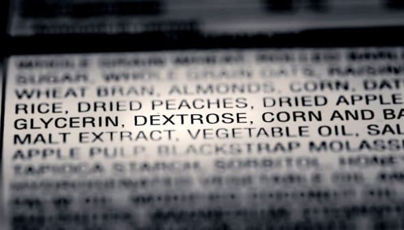 Close-up of an ingredient list on food packaging showing various components including dried fruits and glycerin. - Olive Oil Times