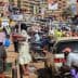 Crowded street in Kampala with pedestrians and vehicles, showcasing daily urban life. - Olive Oil Times