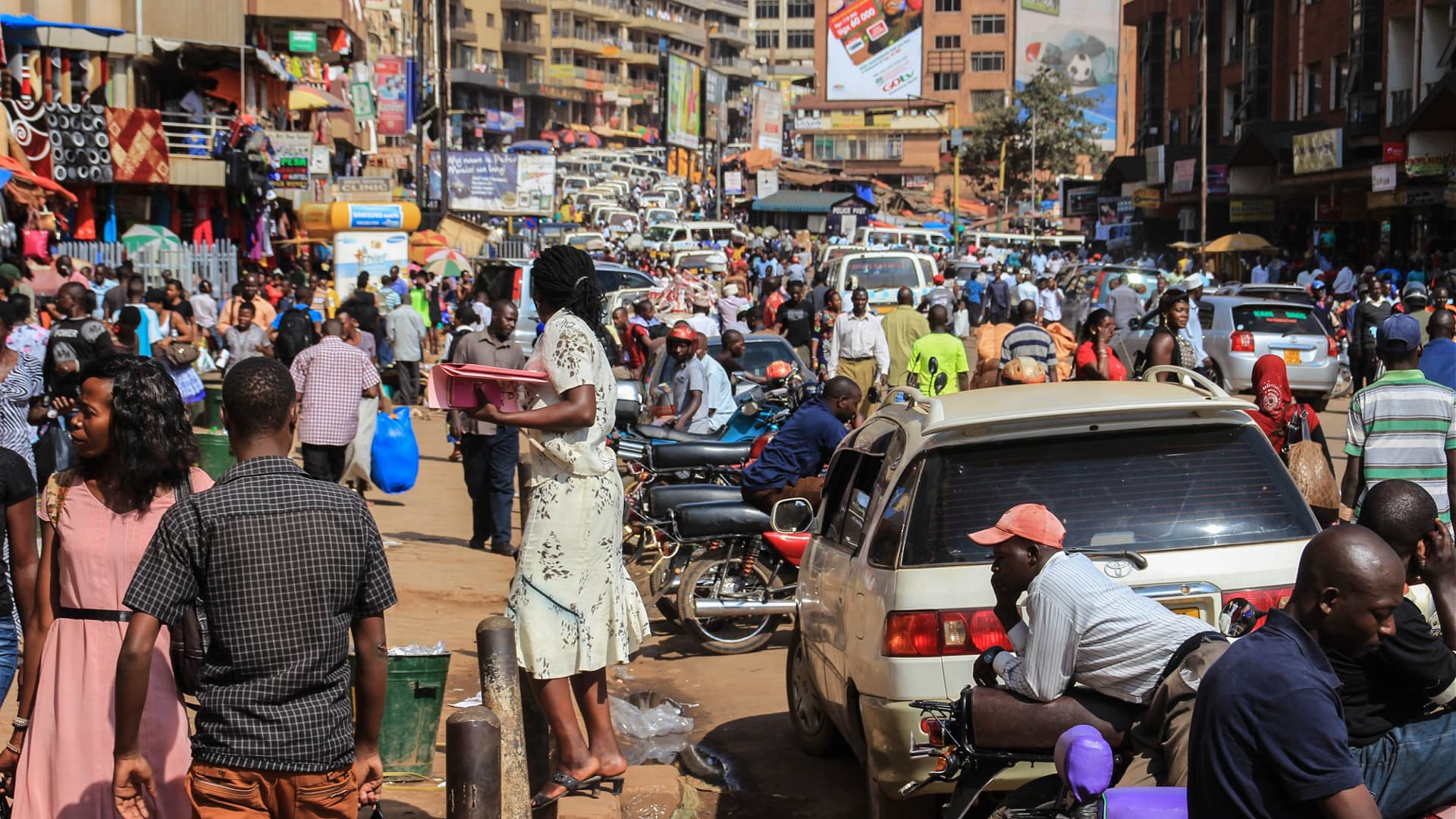 Crowded street in Kampala with pedestrians and vehicles, showcasing daily urban life. - Olive Oil Times
