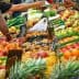 A market stall displaying a wide assortment of fresh fruits including apples, oranges, and avocados. - Olive Oil Times