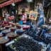 A seafood market displaying various types of shellfish and fish in colorful containers. - Olive Oil Times