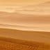 Layered landscape of rolling hills and valleys in warm orange tones during sunset. - Olive Oil Times