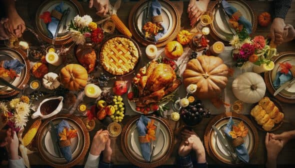 A beautifully arranged Thanksgiving dinner table with a turkey, pie, and various seasonal decorations. - Olive Oil Times