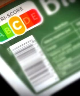 Nutri-Score label displaying letters A, B, C, D, E on food packaging with a barcode. - Olive Oil Times