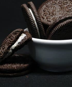 A white bowl filled with Oreo cookies, some cookies stacked and one cookie with cream filling visible. - Olive Oil Times