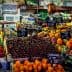 A vibrant display of various fruits and vegetables at a market stall with price tags. - Olive Oil Times