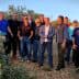 A group of men standing together in an olive grove during daylight. - Olive Oil Times