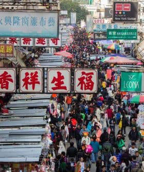 A busy street market in Hong Kong filled with numerous stalls and a large crowd of people. - Olive Oil Times
