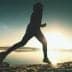 Silhouette of a person jogging along the shore of a lake during sunrise. - Olive Oil Times