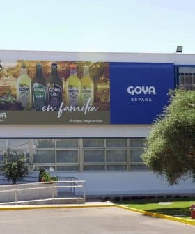 Exterior view of the Goya España building featuring a large advertisement and olive trees. - Olive Oil Times