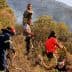 Firefighters and volunteers working together to manage a wildfire in a hilly area with vegetation. - Olive Oil Times